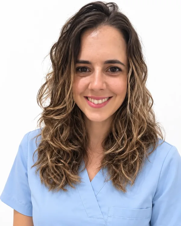 Anabel Carreras, podóloga, sonriendo con uniforme sanitario azul claro